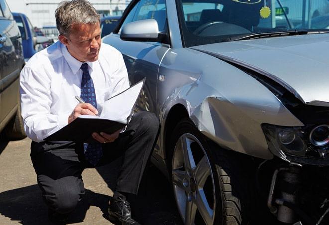 insurance agent explaining policy options to customer with car in background